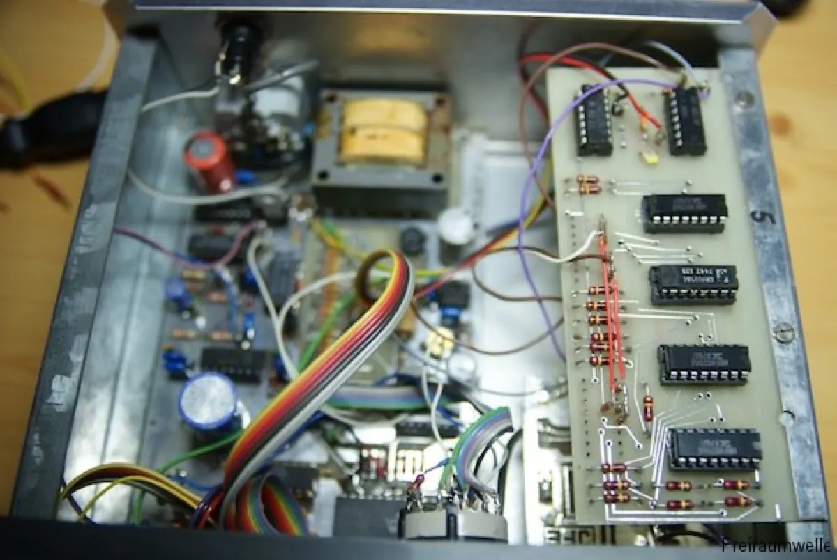 Blick ins geöffnete Gehäuse: die Platine mit der Zählerlogik in bedrahteter Technik, links der kleine Netztransformator