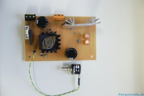 Fertige Platine des Universalnetzteils von oben: LM317 im schwarzen Kühlkörper, zwei Elkos, Schraubklemmen, Sicherungshalter und ein angeschlossenes Wendelpotentiometer