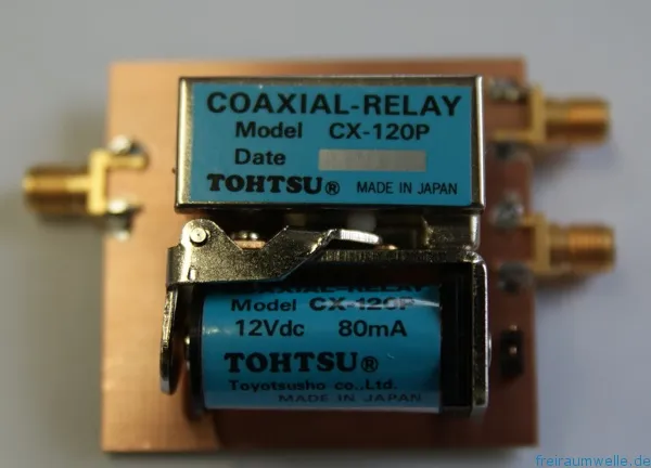 Zwei blaue Koaxialrelais Tohtsu CX-120P nebeneinander auf einer Kupferplatine montiert, mit SMA-Buchsen an den Rändern