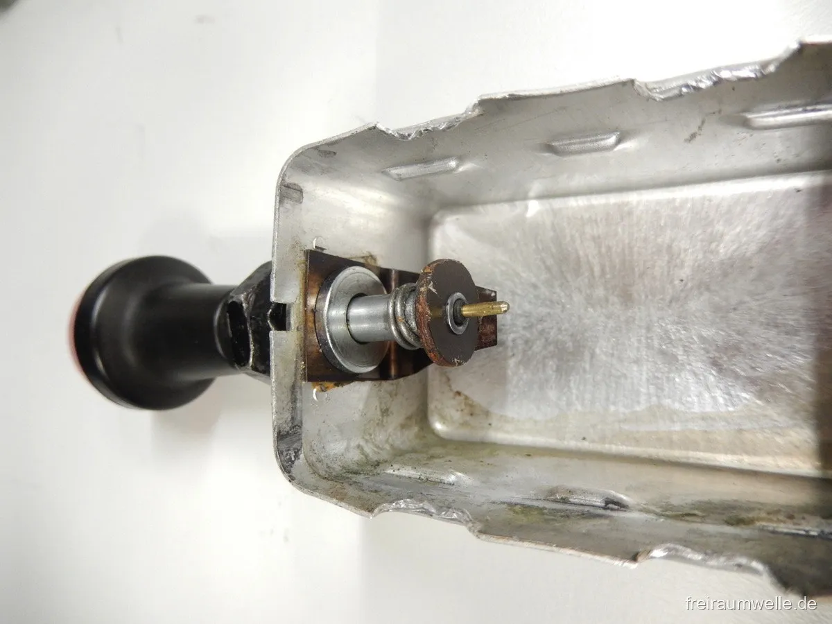 Das leere Gehäuse mit der Schaltmechanik: Achse des Zugknopfs mit Kontaktscheibe und Anschlussfahne