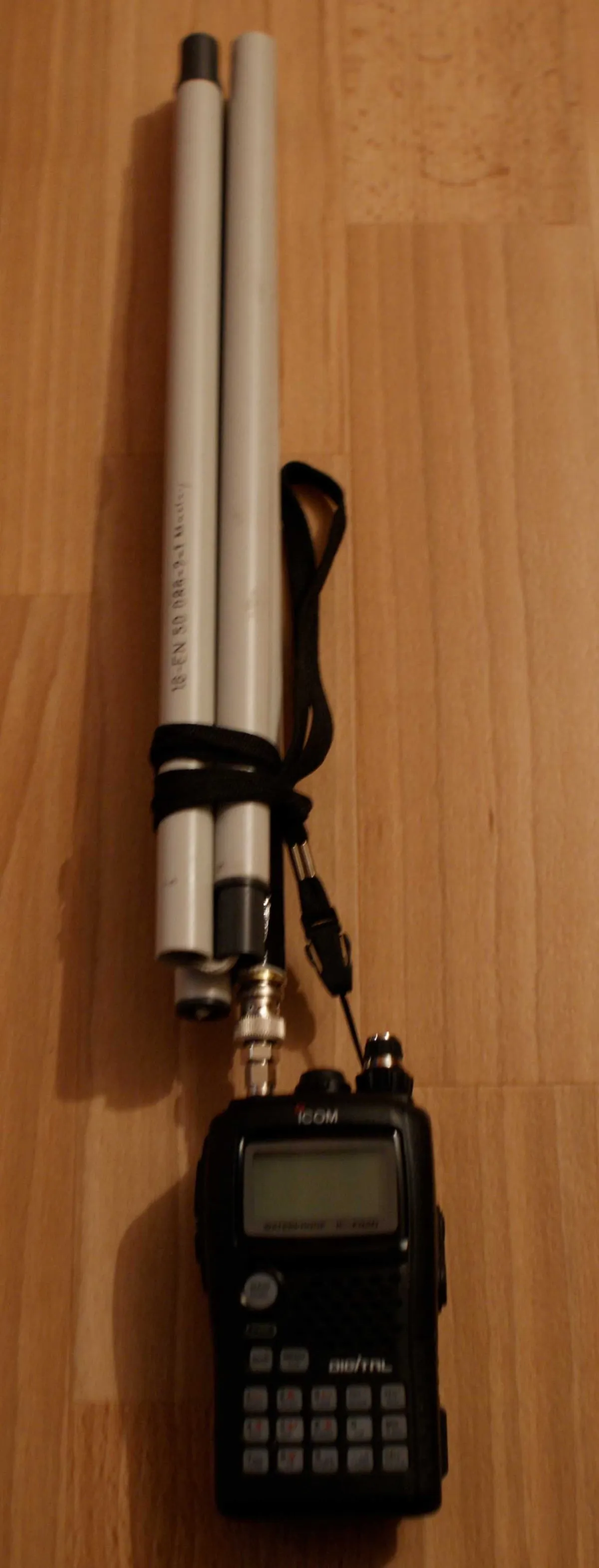 Zusammengelegte Antenne neben dem Handfunkgerät, mit einer Schlaufe gebündelt, kaum länger als das Gerät